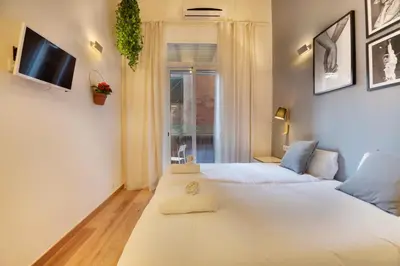 a bedroom with two beds and a tv on the wall at Aqua Apartment by Olala Homes in Barcelona