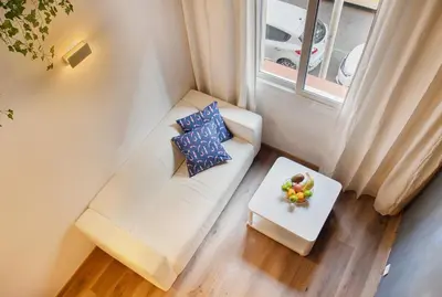 a small living room with a white couch and a table at Aqua Apartment by Olala Homes in Barcelona