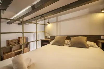 a bedroom with a large white bed and shelves at Aqua Apartment by Olala Homes in Barcelona