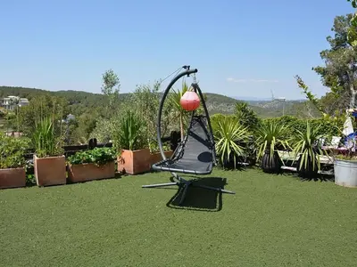 a swing in a yard with grass and plants at Entre Olivos: Very Charming Villa 18 SLEEPERS in Sant Pere de Ribes