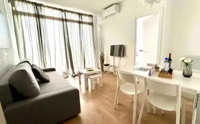 a living room with a couch and a table with chairs at SANTS STATION PENTHOUSE in Barcelona