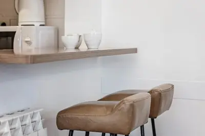a stool sitting under a shelf with bowls on it at Sweett - Comte Urgell in Barcelona