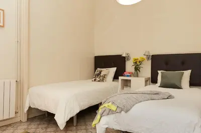 two beds in a room with white walls at Casa Cosi - Gotico in Barcelona