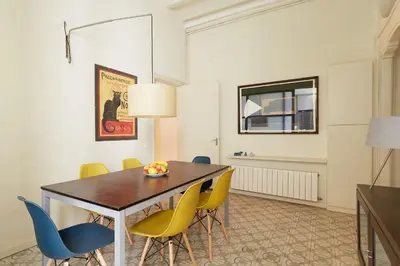 a dining room with a table and yellow chairs at Casa Cosi - Gotico in Barcelona