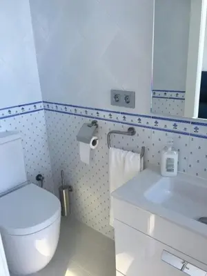 a bathroom with a toilet and a sink and a mirror at Blue sea front by Hello Homes Sitges in Sitges