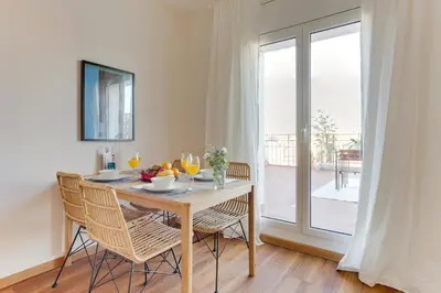 a dining room with a table and chairs and a window at Sweett - The Roca House in Barcelona