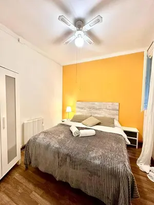 a bedroom with a large bed with a ceiling fan at Big and Bright Apartment BCN in Barcelona