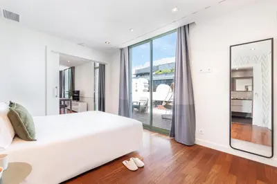 a bedroom with a white bed and a large window at Aspasios Paseo de Gracia Apartments in Barcelona