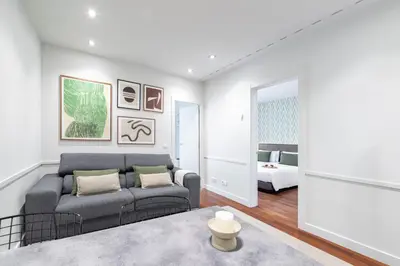 a living room with a couch and a bedroom at Aspasios Paseo de Gracia Apartments in Barcelona