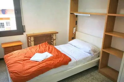 a bed with an orange comforter in a room at Comfortable house near Esparreguera with city view in Esparreguera