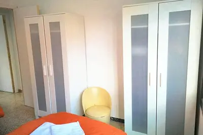 a bedroom with a bed and a cabinet and a chair at Comfortable house near Esparreguera with city view in Esparreguera