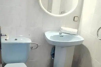 a bathroom with a toilet and a sink and a mirror at Comfortable house near Esparreguera with city view in Esparreguera