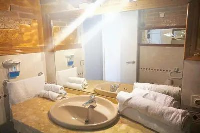 a bathroom with a sink and two mirrors and towels at Comfortable house near Esparreguera with city view in Esparreguera