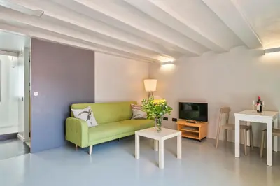 a living room with a green couch and a table at My Address in Plaza Real in Barcelona