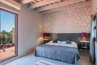 a bedroom with a bed and a large window at My Address in Plaza Real in Barcelona