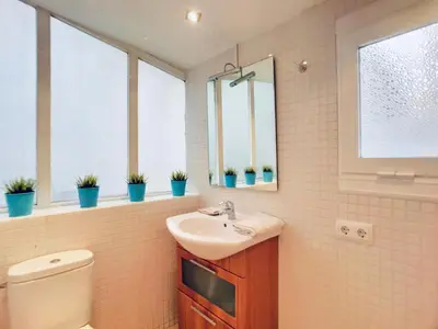 a bathroom with a sink and a toilet and windows at Bed&BCN Gracia II in Barcelona