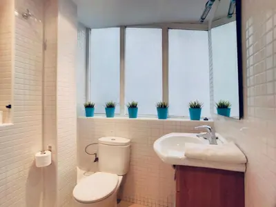 a bathroom with a toilet and a sink and windows at Bed&BCN Gracia II in Barcelona