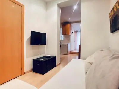 a bedroom with a bed and a television on a wall at Bed&BCN Gracia II in Barcelona