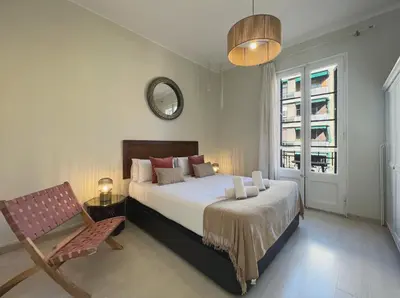 a bedroom with a bed and a chair and a mirror at Stay U-nique Apartments Lepant in Barcelona