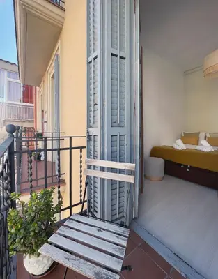 a balcony with a wooden bench and a bed at Stay U-nique Apartments Lepant in Barcelona
