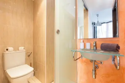a bathroom with a toilet and a sink and a mirror at Matarolux15 in Mataró