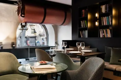 a restaurant with two tables and chairs with wine glasses at Yurbban Ramblas Boutique Hotel in Barcelona