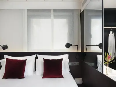 a bedroom with a white bed with red pillows at Yurbban Ramblas Boutique Hotel in Barcelona