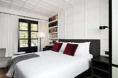 a bedroom with a large white bed with red pillows at Yurbban Ramblas Boutique Hotel in Barcelona