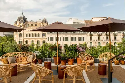 a patio with chairs and umbrellas in front of a building at Yurbban Ramblas Boutique Hotel in Barcelona