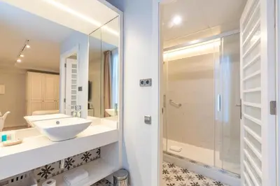a white bathroom with a sink and a shower at Serennia Fira Gran Via Exclusive Rooms in Hospitalet de Llobregat