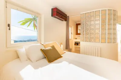 a bedroom with a bed and a sliding glass door at Stunning Villa Ibizenca with private pool in Sitges in Sitges