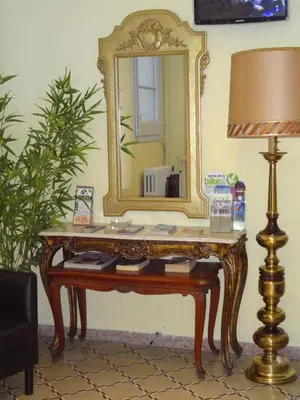 a dressing table with a mirror and a lamp at Hostal Sant Carlo in Barcelona
