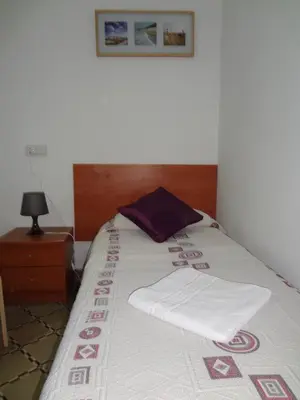 a bed with two white towels on top of it at Hostal Sant Carlo in Barcelona