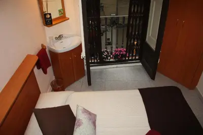 a small bathroom with a bed and a sink at PENSIÓN Colmenero in Barcelona