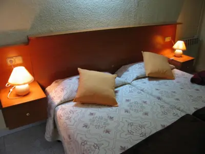 a bedroom with a bed with two lamps on it at PENSIÓN Colmenero in Barcelona