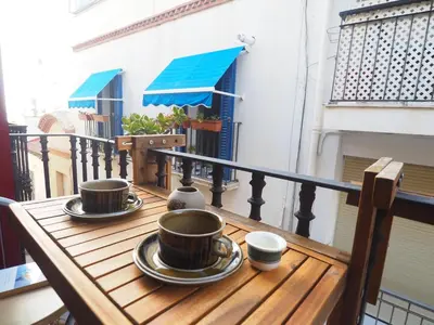 a table with two coffee cups on a balcony at Balcony View Apartment by Hello Homes Sitges in Sitges