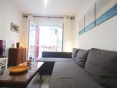 a living room with a couch and a table at Balcony View Apartment by Hello Homes Sitges in Sitges