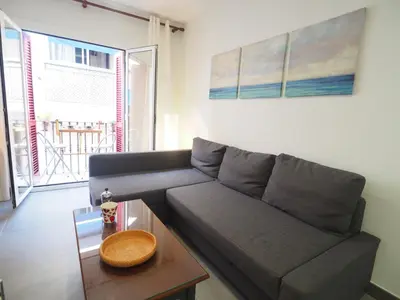 a living room with a couch and a table at Balcony View Apartment by Hello Homes Sitges in Sitges