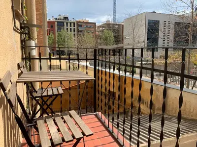 a balcony with a table and bench on a balcony at Charm Miró in Barcelona