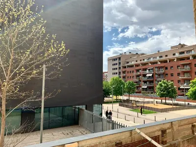a building with a tree in front of a building at Charm Miró in Barcelona