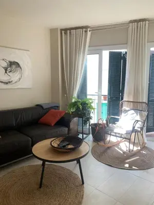 a white bedroom with a bed and a mirror at Casa Susana in Sitges