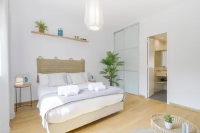 a white bedroom with a large bed with towels on it at Sweett - Monumental in Barcelona