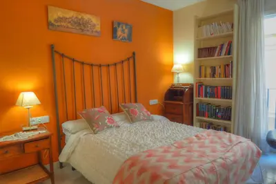 a bedroom with a bed and a book shelf at Center Family Apartment by Hello Homes Sitges in Sitges