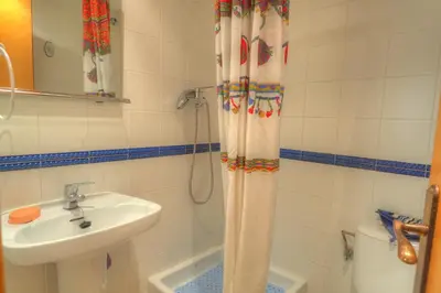 a bathroom with a sink and a shower curtain at Center Family Apartment by Hello Homes Sitges in Sitges