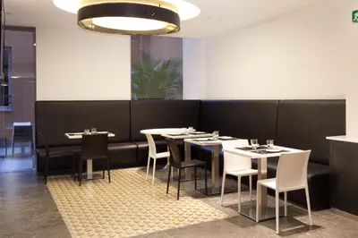 a dining room with tables and chairs and a chandelier at Dalia Ramblas in Barcelona