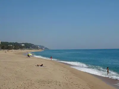 a group of people on a beach near the water at Duplex en frente de la playa al lado de Barcelona in Canet de Mar