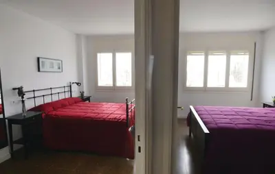 a bedroom with two beds with red sheets at Duplex en frente de la playa al lado de Barcelona in Canet de Mar