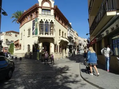 a group of people walking down a street in front of a building at Duplex en frente de la playa al lado de Barcelona in Canet de Mar