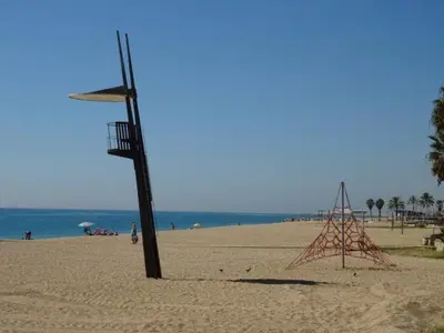 a volleyball hoop on a beach next to the ocean at Duplex en frente de la playa al lado de Barcelona in Canet de Mar