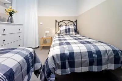 a bedroom with two beds with blue and white checks at Apartamento con Terraza, Balcón de Barcelona in Esplugues de Llobregat